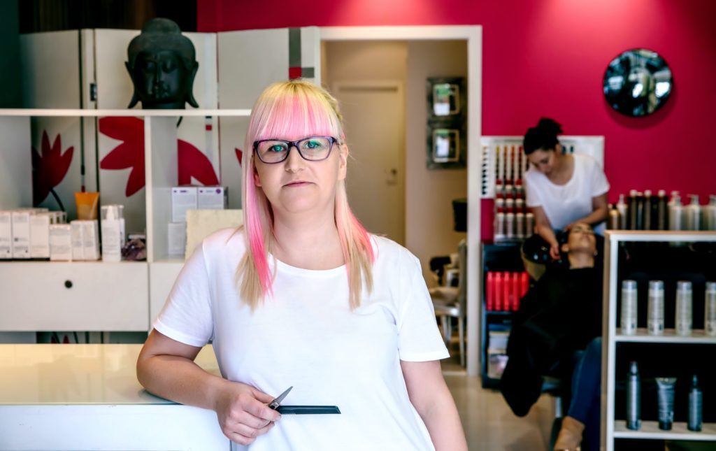 Woman hairdresser standing in hair and beauty salon